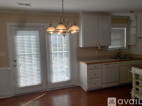 A kitchen with white cabinets and a wooden island.