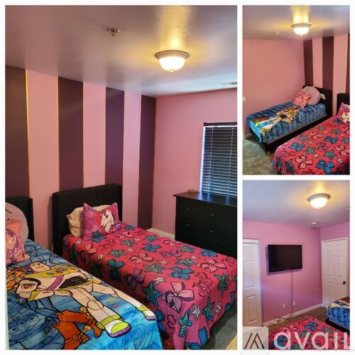 A bedroom with two beds and a television.