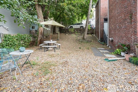 A backyard with a picnic table and chairs.