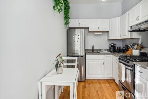 A kitchen with white cabinets and a wooden floor.