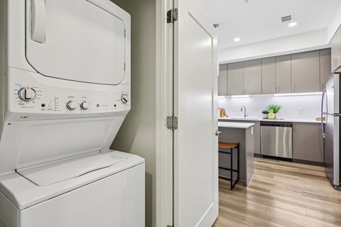A white dishwasher is in a kitchen with a white oven.