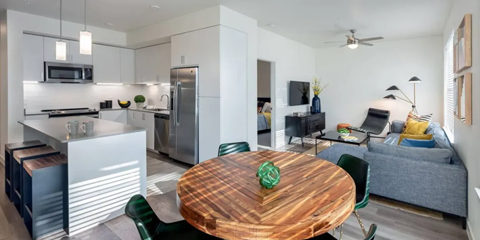 A modern kitchen with a dining table and chairs in the foreground.