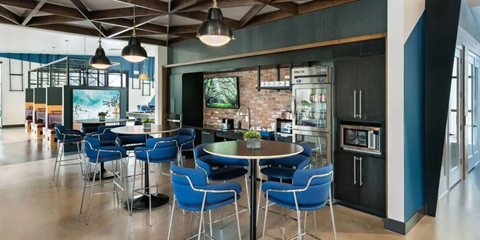A modern dining area with a round table surrounded by blue chairs.