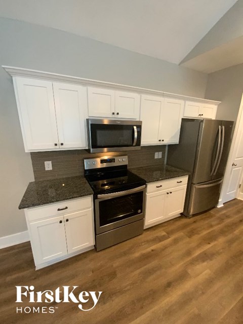 A kitchen with a stove top oven and a refrigerator.