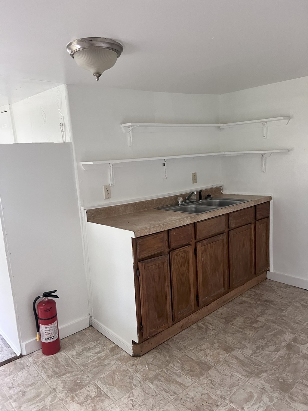 A red fire extinguisher is on the floor next to a kitchen island.