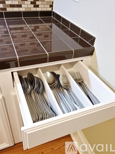 A kitchen with white cabinets and a stainless steel refrigerator.