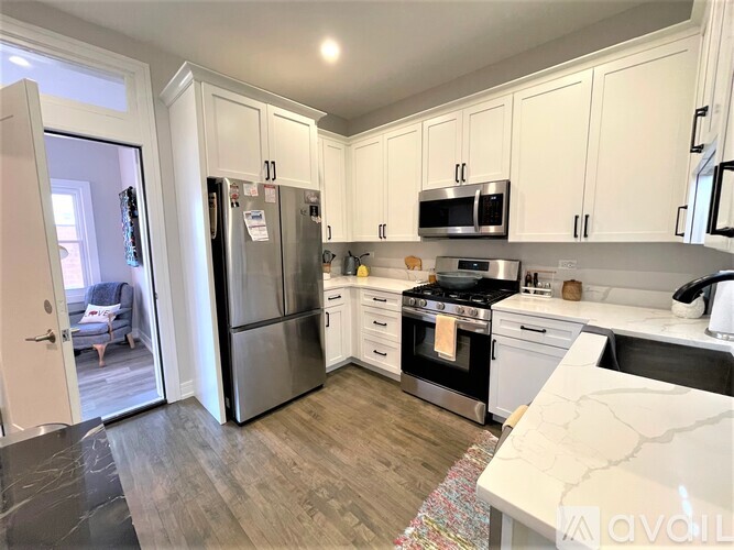 A kitchen with white cabinets and a refrigerator.