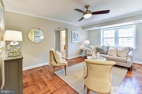 A living room with a beige chair and a white couch.