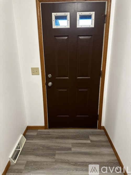 A brown door with two windows above it.