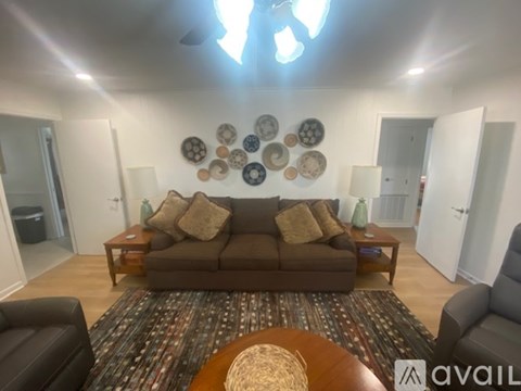 A living room with a brown couch and a rug.