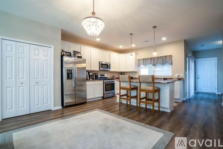 A kitchen with white cabinets and a wooden floor.