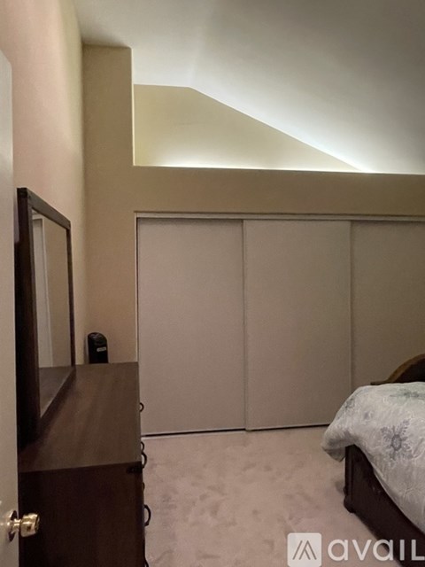 A bedroom with a bed, wardrobe and a mirror.