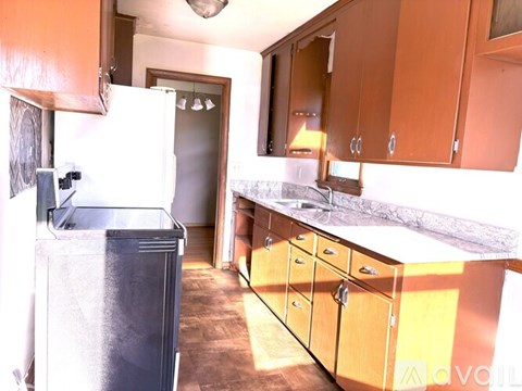 A kitchen with wooden cabinets and a refrigerator.