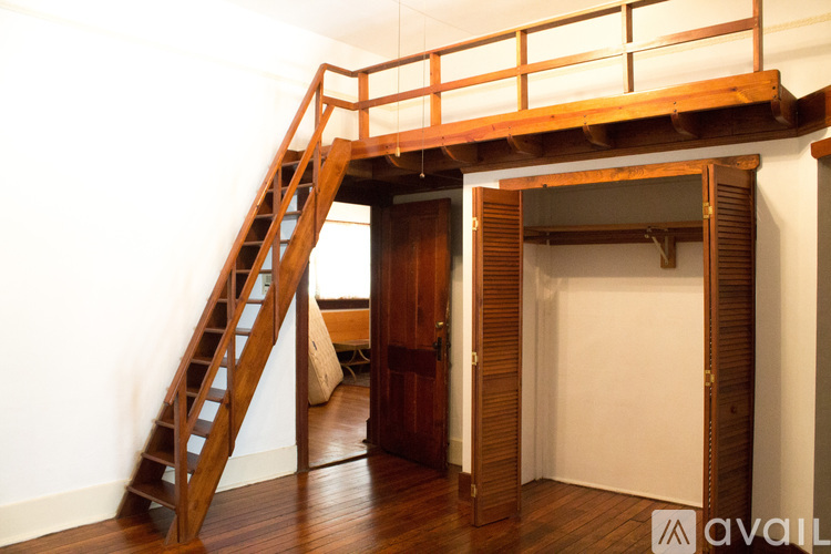 A wooden staircase with a balustrade leads up to a doorway.
