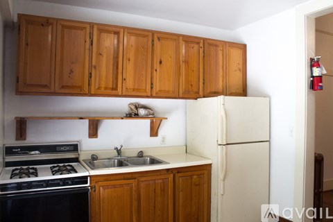 A kitchen with wooden cabinets and a white refrigerator.