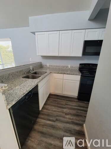 A kitchen with white cabinets and a granite countertop.