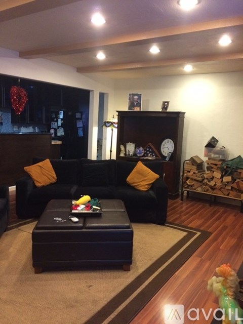 A living room with a black couch and a coffee table.