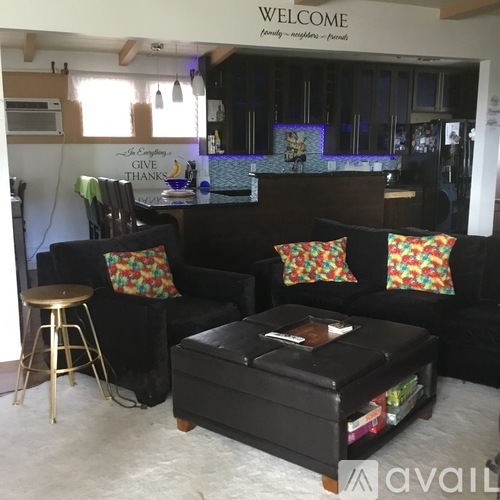 A black couch with colorful pillows sits in a living room.