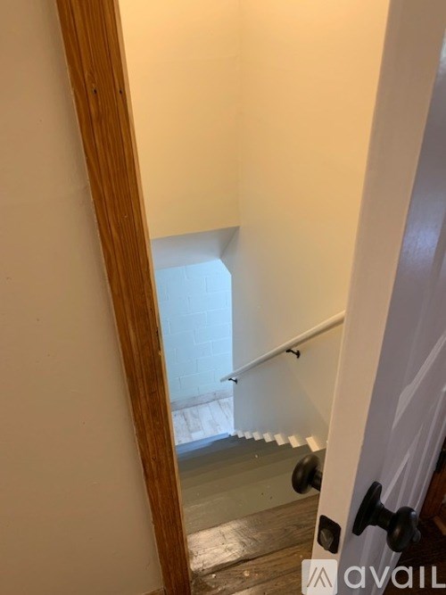 A hallway with a wooden door and a white door.