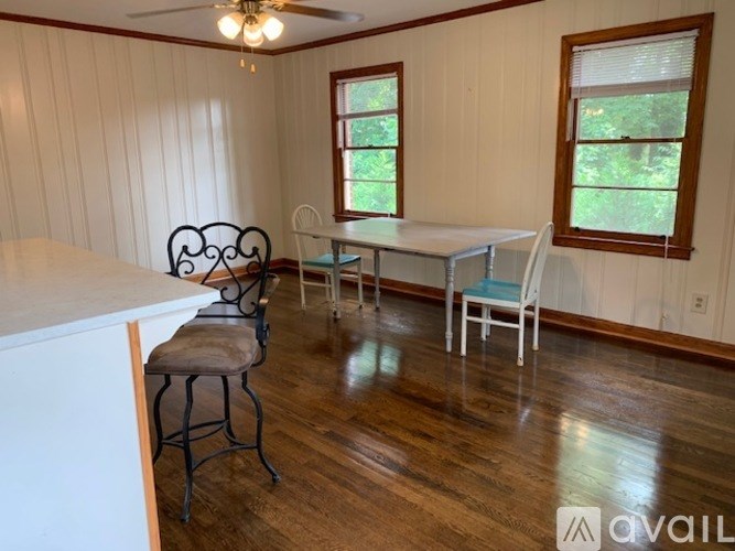 A room with a table and chairs and a window.