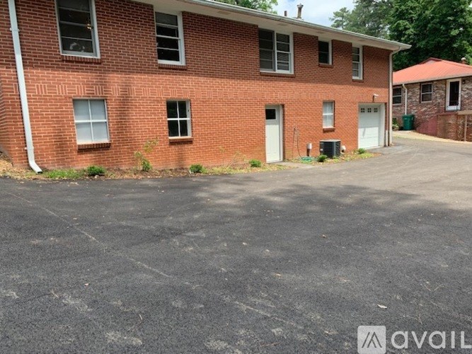 A red brick building with a white door and windows.