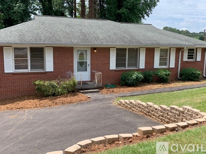 A brick house with a white door and windows.