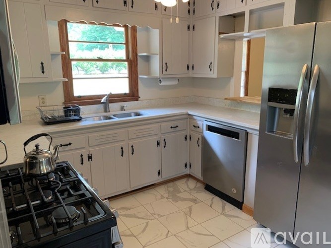 A kitchen with white cabinets and a black stove top.