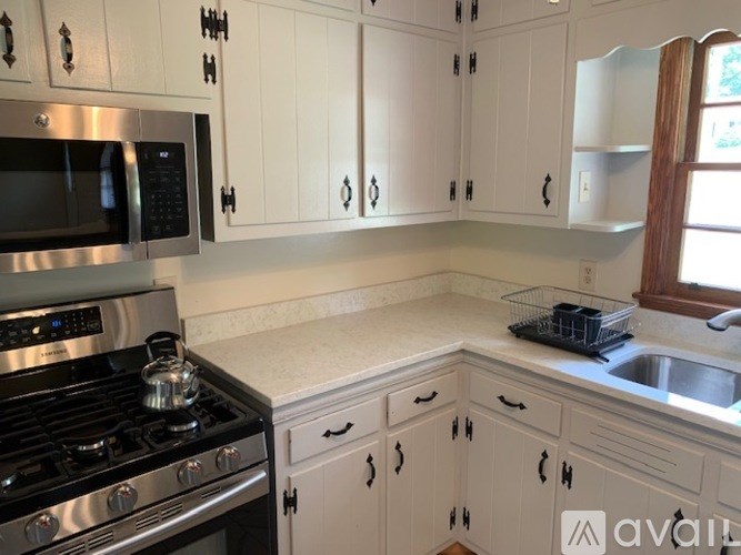 A kitchen with white cabinets and a black stove top.