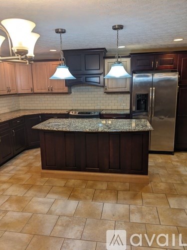 A kitchen with a granite countertop and tile flooring.