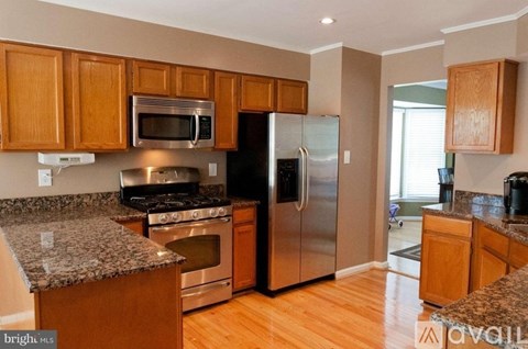 A kitchen with wooden cabinets and stainless steel appliances.