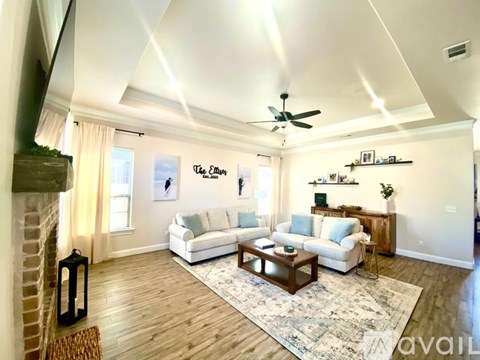 A living room with a white couch and a wooden coffee table.