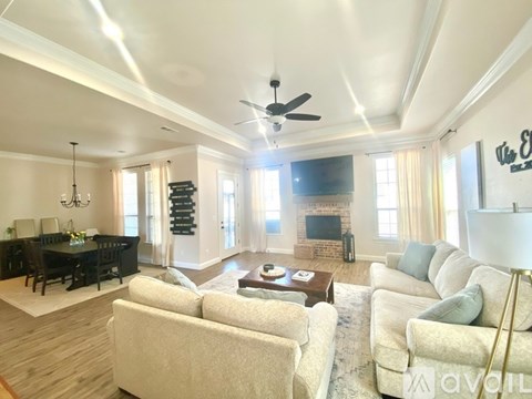 A spacious living room with a fireplace and a dining table.