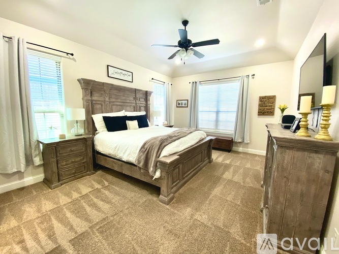 A bedroom with a large bed and a wooden headboard.