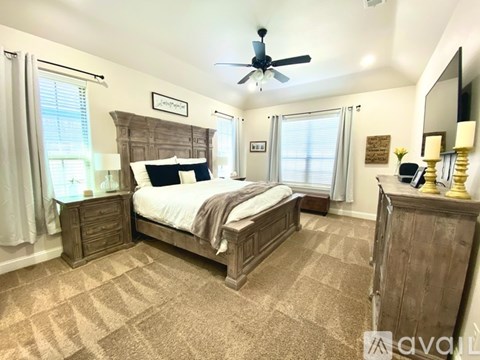A bedroom with a large bed and a wooden headboard.