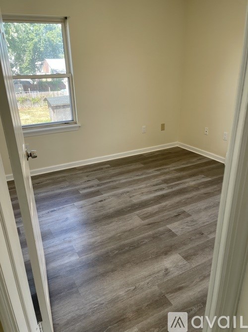 A room with wooden flooring and a window.