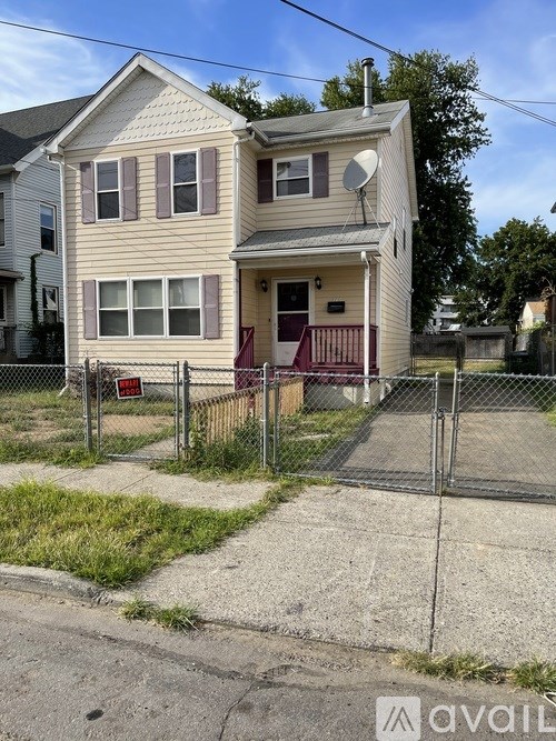 A two-story house with a fenced front yard.