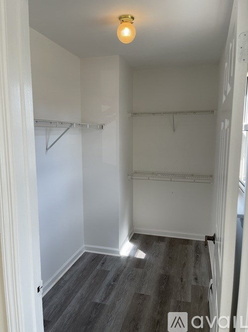 A room with a grey floor and a white wall with a hanger on the wall.