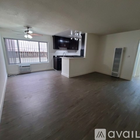 A living room with a television and a ceiling fan.