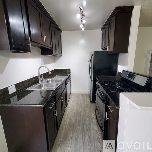 A kitchen with black cabinets and a black stove top oven.