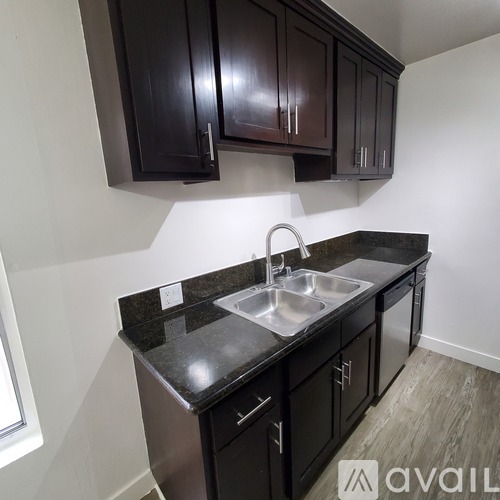 A kitchen with dark brown cabinets and a granite countertop.