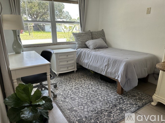 A bedroom with a bed, desk, and chair.