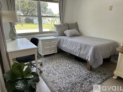 A bedroom with a bed, desk, and chair.