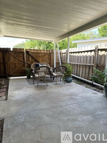 A patio with a table and chairs under a roof.