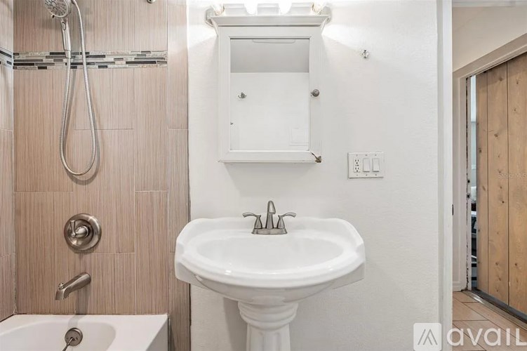 A white sink in a bathroom with a shower and a towel rack.