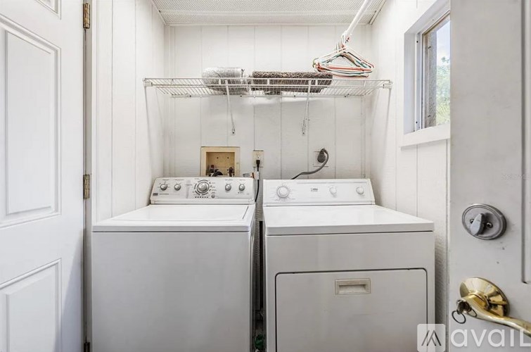 A white laundry room with a washer and dryer.