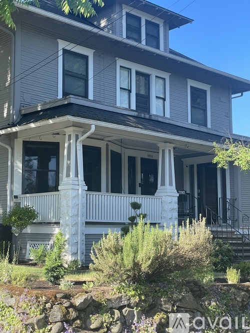 A house with a grey facade and white columns.