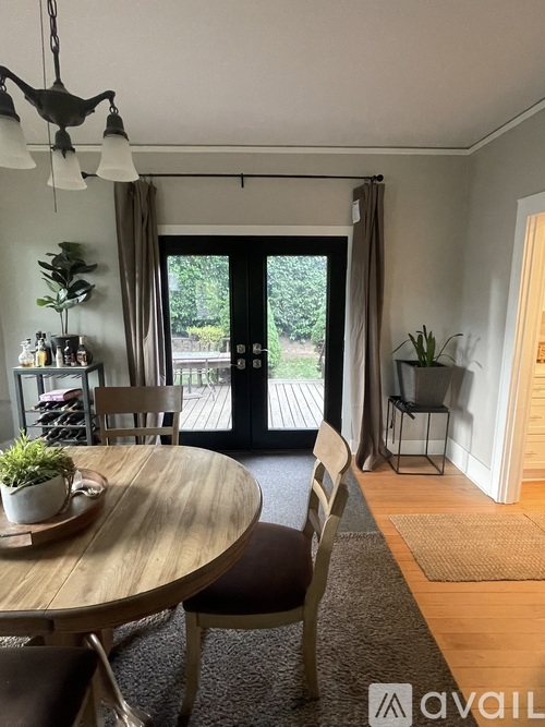 A dining room with a round wooden table and chairs.
