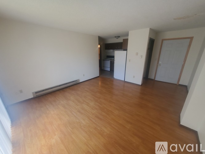 A room with wooden flooring and a black table.