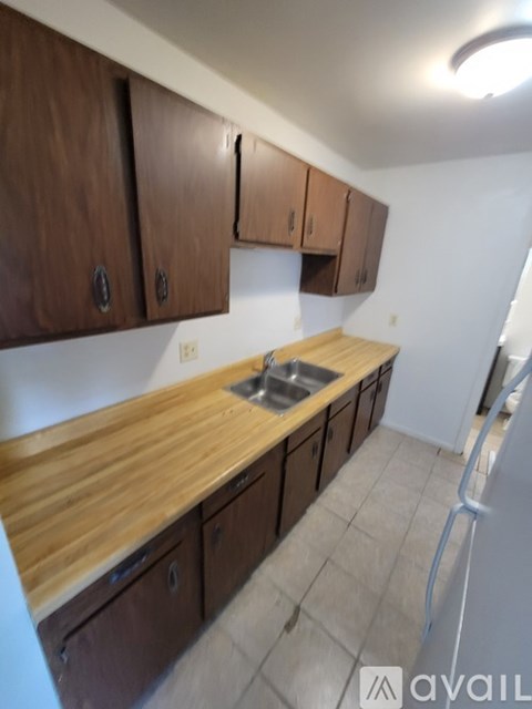A kitchen with wooden cabinets and a sink.