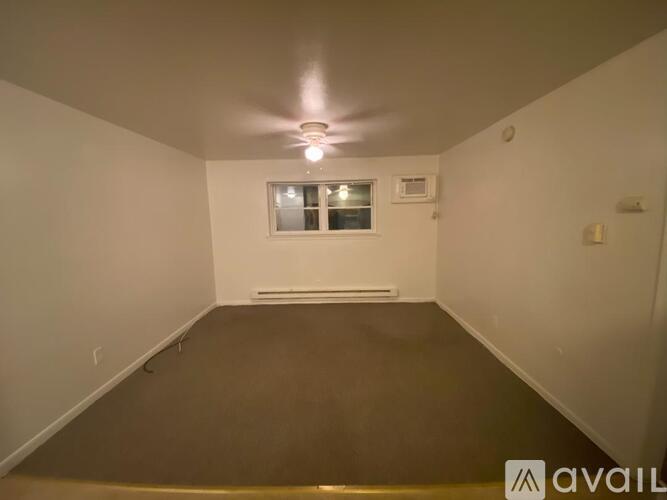 A room with a window and a light on the ceiling.